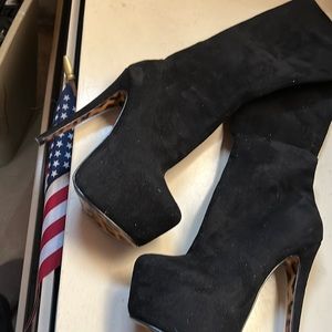 Black platform knee-high boots with leopard bottom
